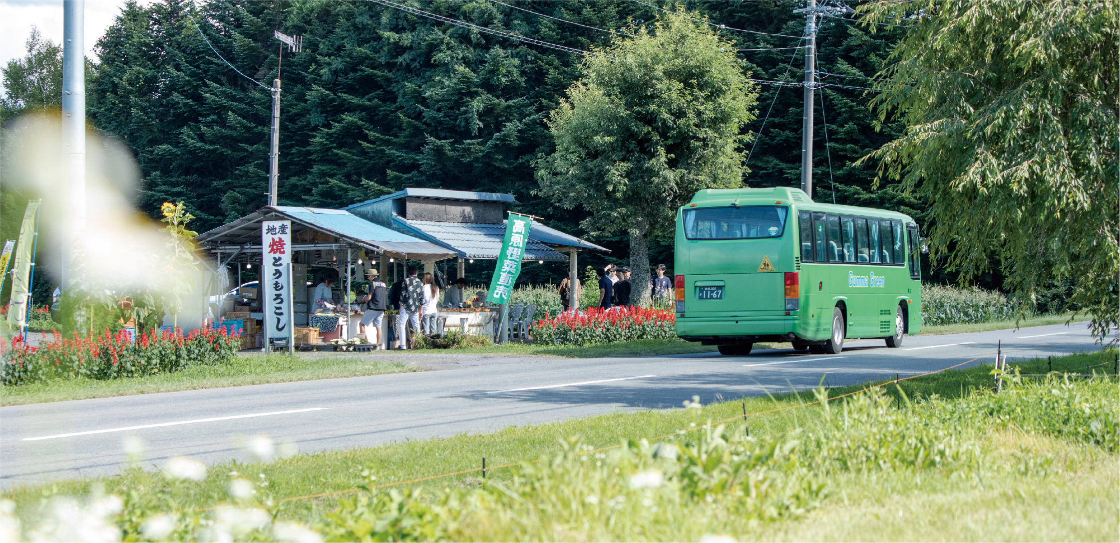 花に囲まれた嬬恋村のバス停に停まる群馬グリーン交通のバス