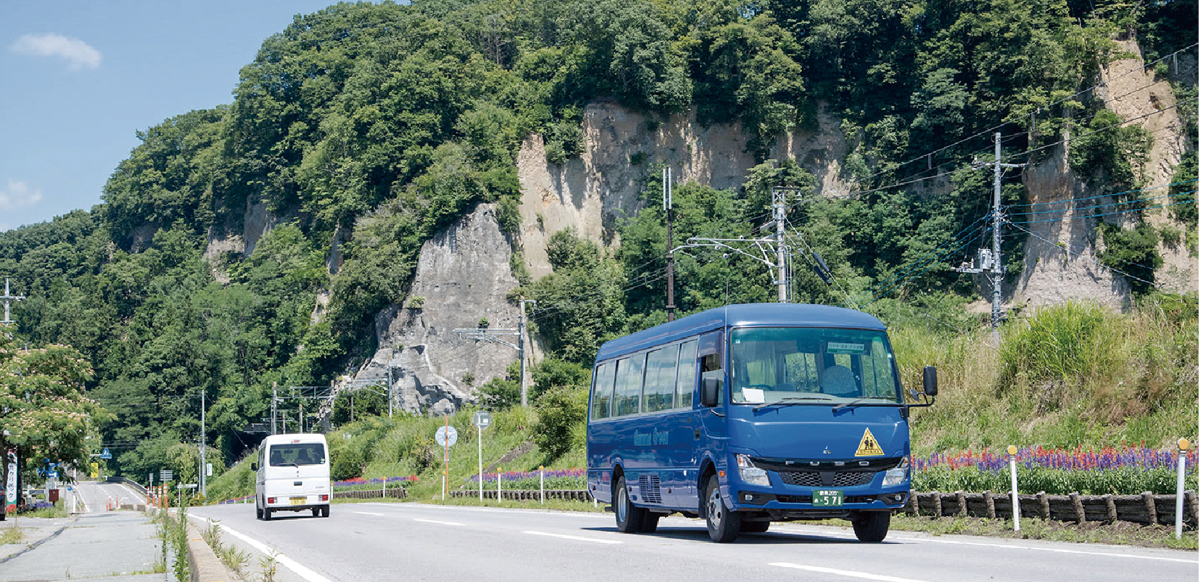 嬬恋村の山と川の風景を走る群馬グリーン交通のスクールバス2台
