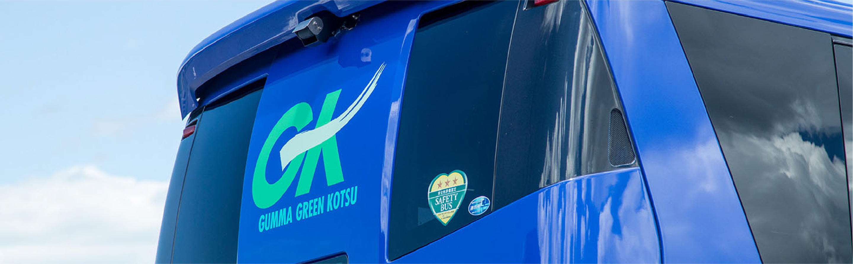 嬬恋村の広大な緑の風景を走るバス